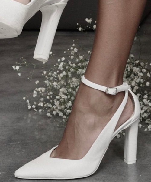 Décolleté bianca a punta con cinturino alla caviglia e tacco largo, indossata — Tulle Calzature, Torino
